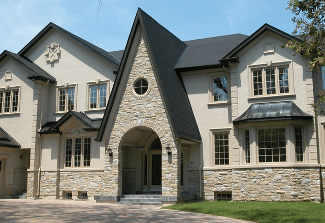 Modern two-story home with Universal stucco finish, warm beige exterior walls, and natural wood front door accents, 2026 architectural trend